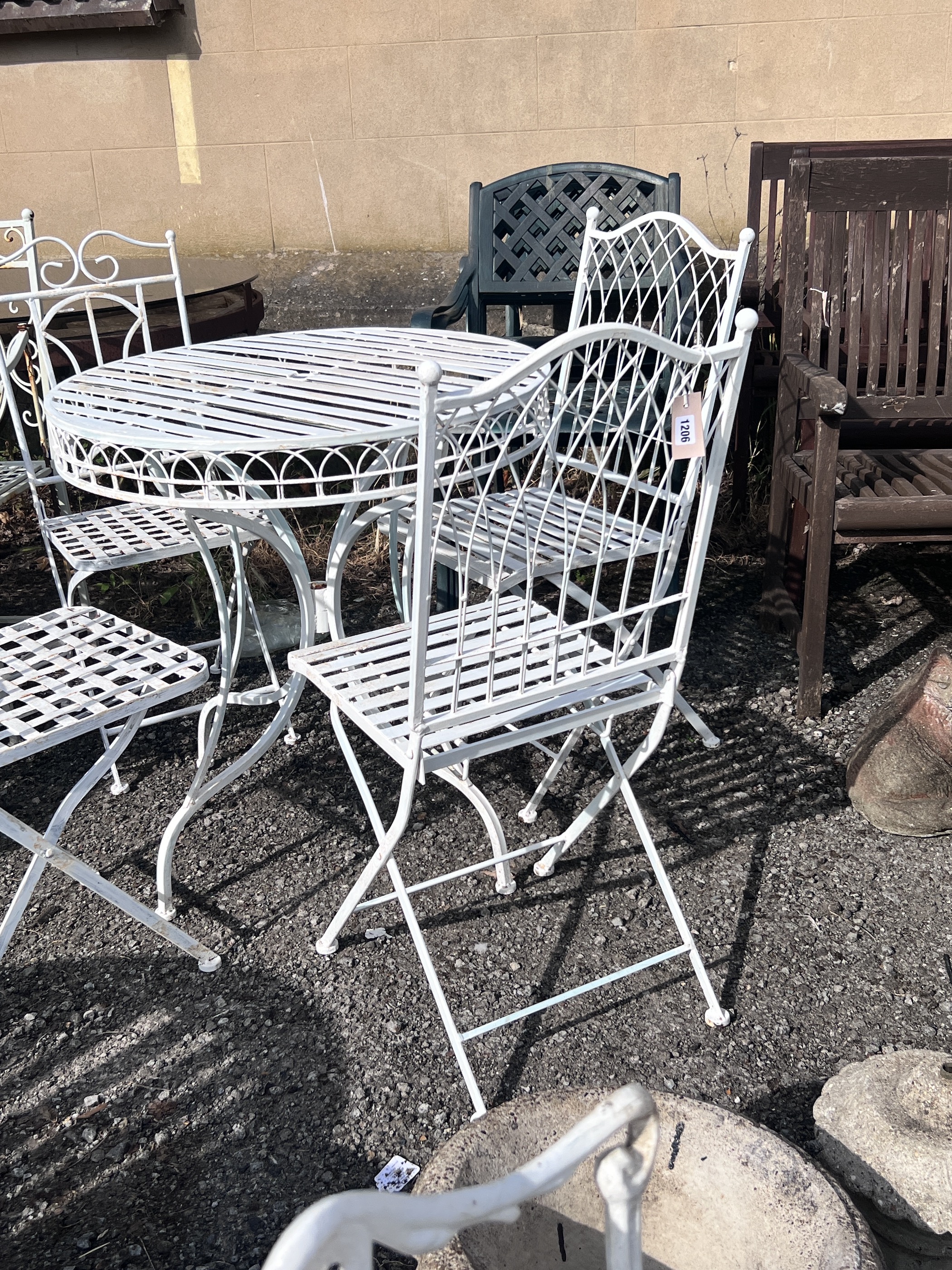 A circular painted aluminium garden table, diameter 74cm, height 77cm, and four folding garden chairs